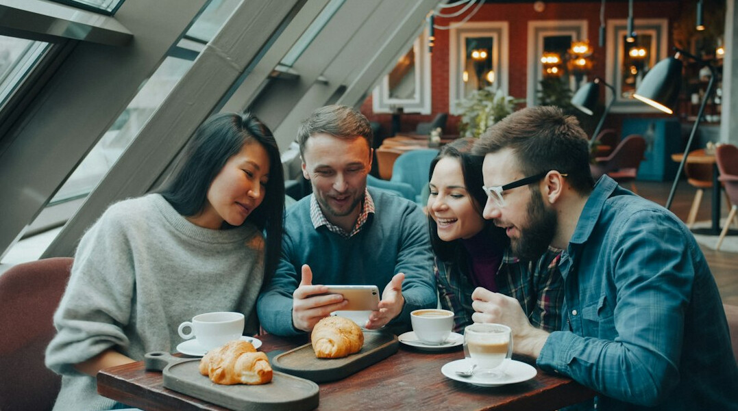 Group of people collaborating around a laptop